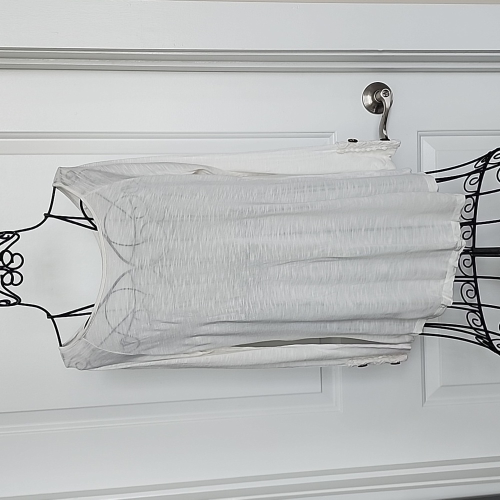 white, long sleeved top. Brown button details (back and sleeves).